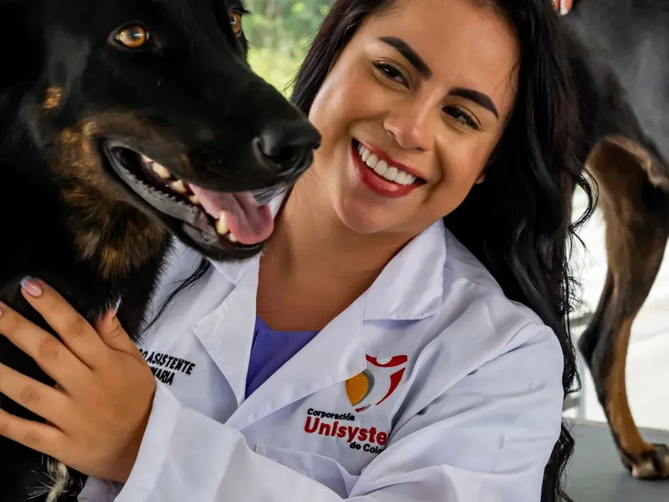 Estudiante de Unisystem junto a un perro en un espacio de atención veterinaria.